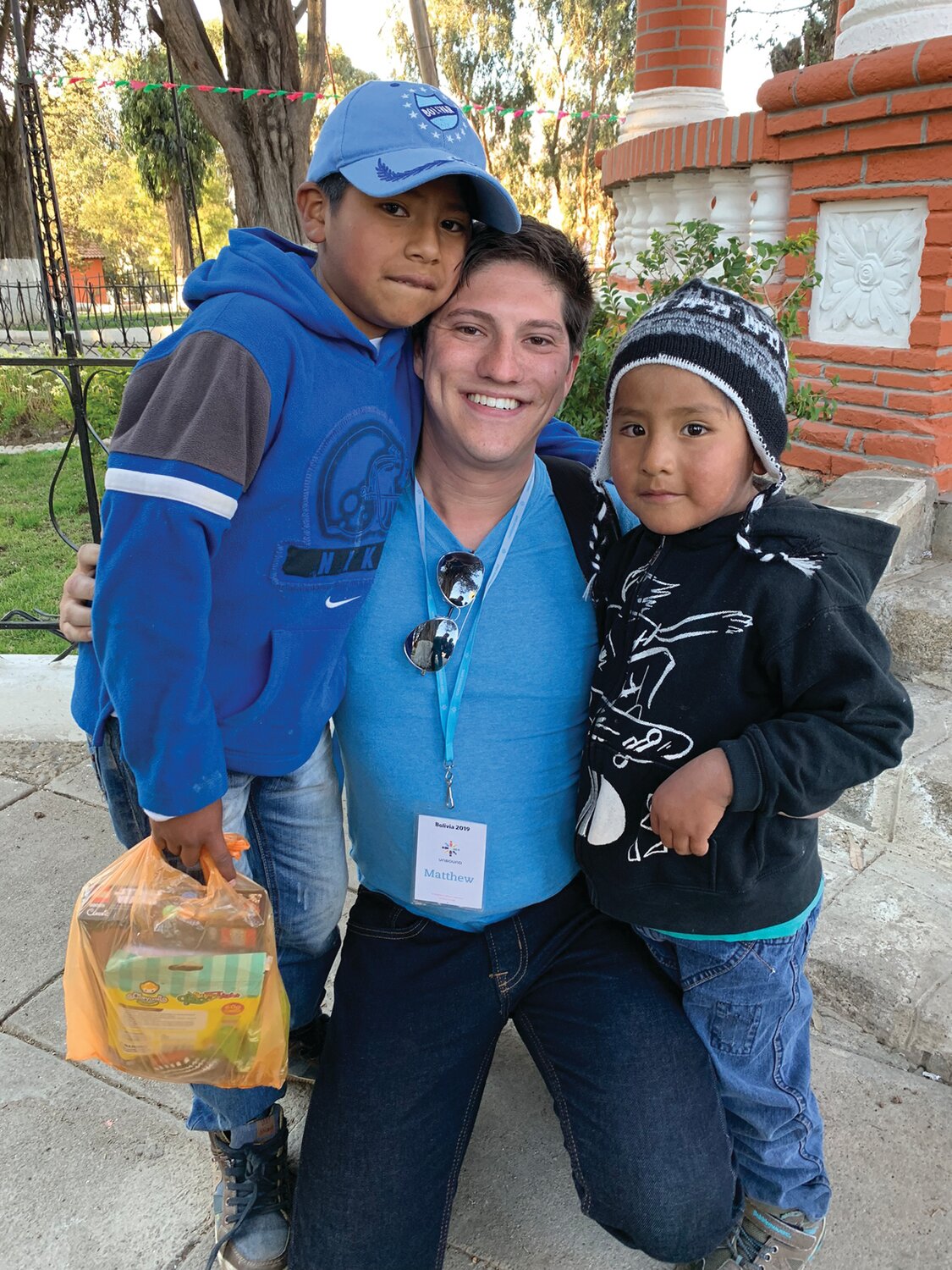 MAKING A DIFFERENCE: Matthew Gebhart (center) smiles as he visits Bolivia to see the boy he sponsors, Jhamil (left), and his brother, sponsored by Gebhart’s parents, Jhafet in 2019. (Submitted Photo)